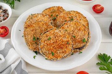 Baked garlic crispy eggplant with tomato sauce on a plate. Vegetarian food. Selective focus, top view.