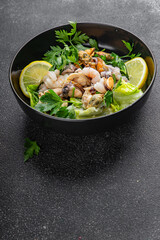Seafood salad fruit de mer shrimp, mussels, squid, rapawn, prawn, green mixed leaf dish fresh food background on the table rustic food top view copy space keto paleo diet vegetarian pescetarian