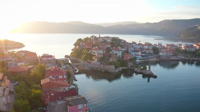 The unique beauty of Amasra, the pearl of Bartın, at sunset is immortalized by a drone camera. It creates a peaceful image by illuminating the historical structures and natural surroundings of Amasra.