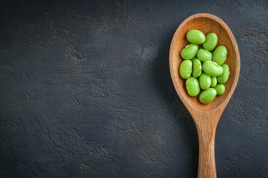 Wooden spoon filled with lima beans 