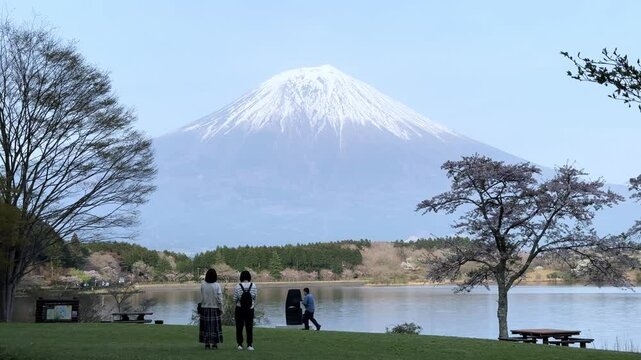 Scenic view of Lake Tanuki with Mount Fuji in the background and people walking