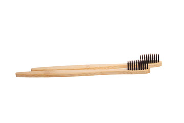 A pair of biodegradable bamboo toothbrushes with black bristles, featuring smooth wooden handles, isolated on a white background. Perfect for eco-friendly oral care and zero-waste living