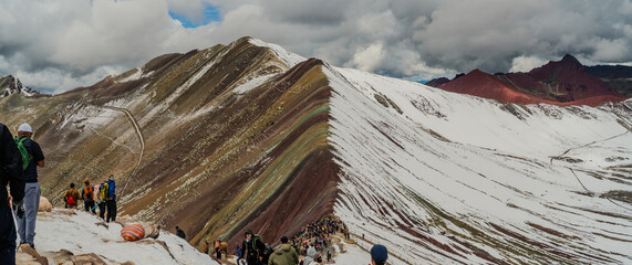 Vibrant Rainbow Mountain (Vinicunca) in the Peruvian Andes with Tourists Exploring the Summit, Snow covered mountain peaks, High Elevation Hikes
