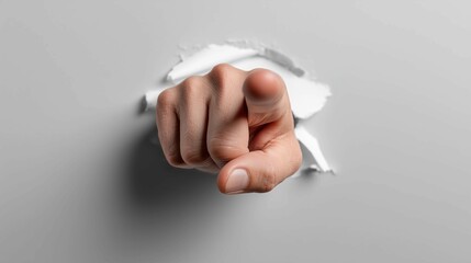 Pointing finger breaking through white sheet of paper,focus or attention on one point