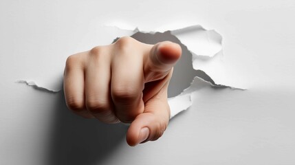 Pointing finger breaking through white sheet of paper,focus or attention on one point