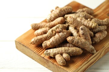 Raw tumeric rhizomes on white table, closeup
