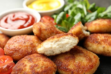 Many tasty patties on dark table, closeup