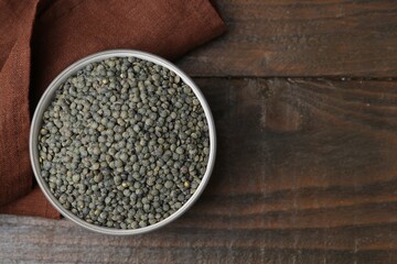 Raw green lentils on wooden table, top view. Space for text