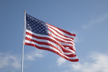 Fototapeta premium minimalistic shot of american flag gently waving in breeze set against clear blue sky with ample copy space