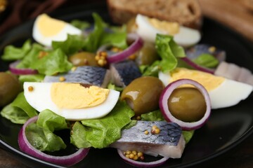 Delicious salad with herring, egg, mustard and vegetables on table, closeup