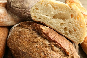 Different loaves of fresh bread on table, closeup