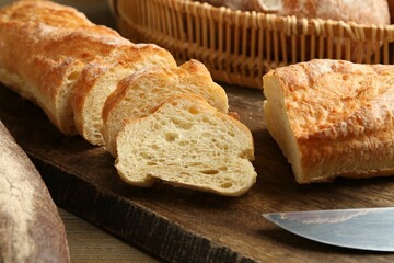 Different types of fresh bread on wooden table, closeup