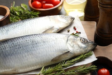 Salted herrings, spices and tomatoes on table, closeup