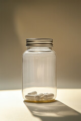 Several white capsules in a transparent jar