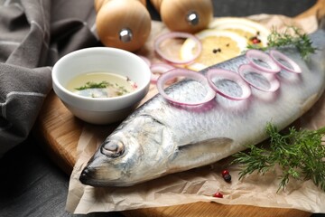 Tasty herring with spices on black table, closeup