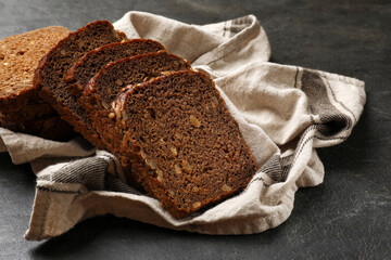 Pieces of fresh bread on black table, closeup