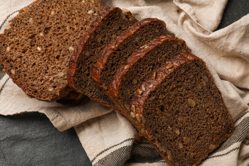 Pieces of fresh bread on black table, top view