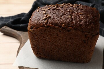 Fresh loaf of bread on wooden table, closeup