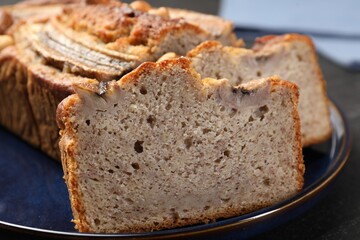 Cut banana bread with nuts on table, closeup
