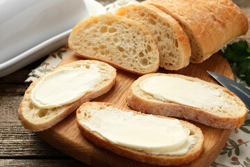 Pieces of bread with butter on wooden table, closeup