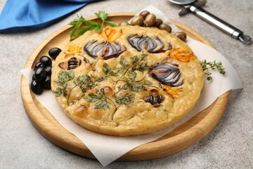 Delicious focaccia with flowers made of vegetables and cutter on grey table, closeup