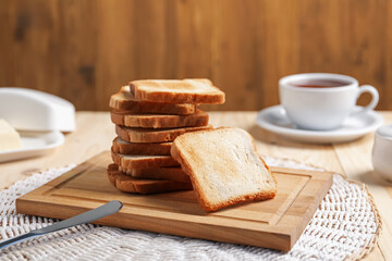 Slices of tasty toasted bread on wooden table, closeup