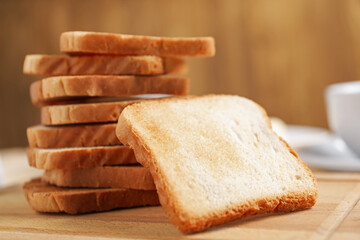 Slices of tasty toasted bread on wooden board, closeup