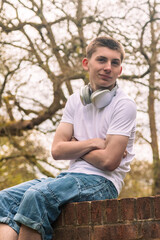 Obraz premium Teenage boy sitting on a brick wall