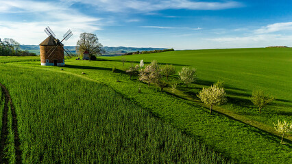 aerial drone view of chvalkovice windmill surrounded by spring blossoms