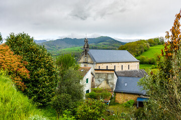 Obraz premium Church of Saint-Barthélemy in a green and hilly landscape characteristic of the Couserans region in spring in the village of Castillon-en-Couserans