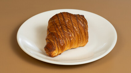 Croissant on white plate isolated