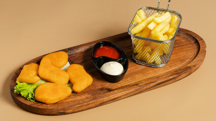 Fries basket and fried cheese on wooden tray
