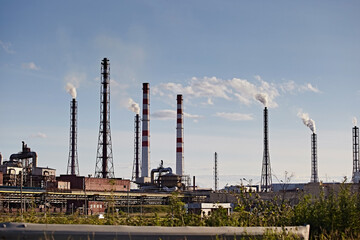 Metallurgical plant chimneys with smoke against the sky