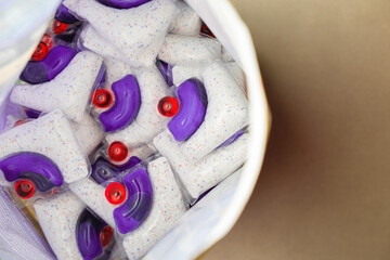 Colorful laundry pods in a container ready for washing clothes at home