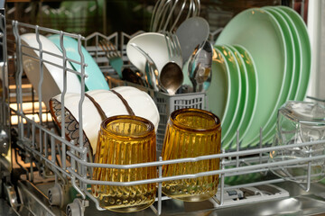 Brightly colored dishes and glassware organized neatly in a dishwasher