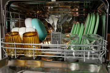 Organizing a modern kitchen with clean dishes and utensils in a dishwasher