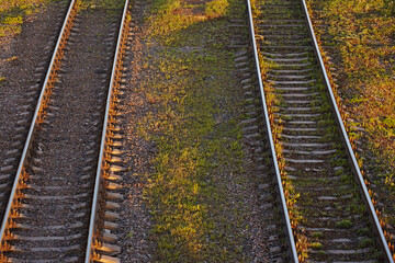 Fototapeta premium Top view: two railway tracks at sunset, close-up
