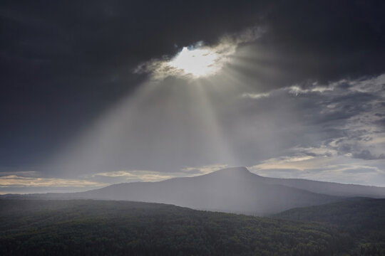 Sun rays silhouette mountain