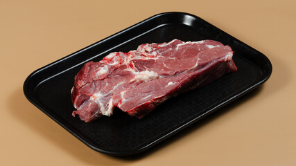 Raw meat on black tray