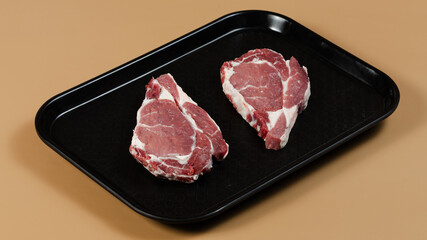 Raw meat on black tray