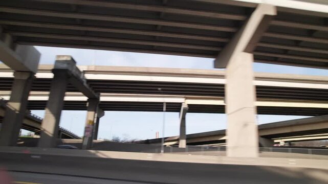 Vehicle driving point of view underneath highway and interstate overpass road roadway with construction and infrastructure in the north hills of the greater Pittsburgh, Pennsylvania area
