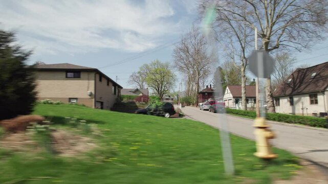 Moving past Pittsburgh, PA greater area suburbs and neighborhood homes in western Pennsylvania in warm, sunny spring weather in April of residential areas in North Hills suburban roads and houses
