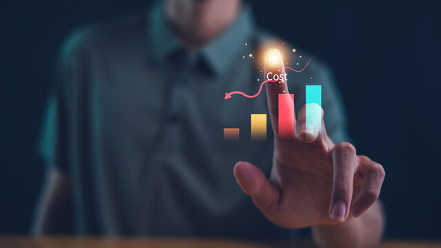 Business pointing down arrow of the graph with cost reduction business finance on virtual screen. Cost reduction concept.
