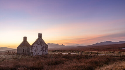 Sunrise behind the Moine House. A ruin of a stone cottage in the remote moorland in Sutherland in the far north of the Scottish Highlands.