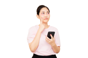 A thoughtful woman in a pink shirt holds a smartphone while pondering, with her finger resting on her cheek.