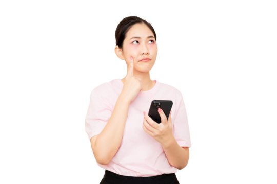 A thoughtful woman in a pink shirt holds a smartphone while pondering, with her finger resting on her cheek.