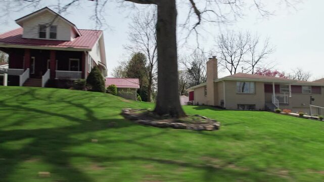 Moving past Pittsburgh, PA greater area suburbs and neighborhood homes in western Pennsylvania in warm, sunny spring weather in April of residential areas in North Hills suburban roads and houses