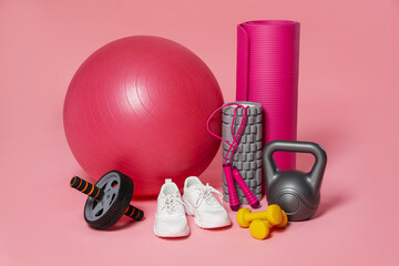 Many different fitness equipment on pink background