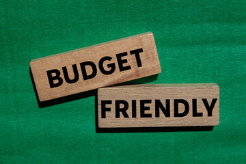 Budget friendly message written on wooden blocks on green background. Conceptual budget friendly...
