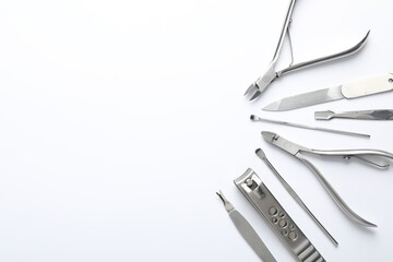 Set of different manicure tools on white background, flat lay. Space for text